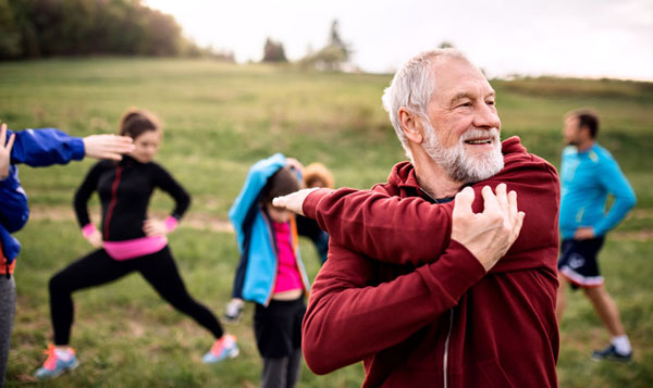 Man stretching and pleole stretching in background